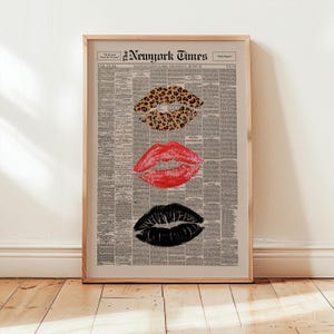 May include: Framed print featuring three sets of lips in leopard print, red, and black, set against a vintage newspaper background. The top of the print displays "The New York Times" and other text.