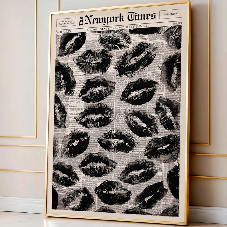 May include: A framed print featuring a collage of black lipstick kiss marks over a vintage newspaper background. The newspaper is titled "The New York Times" with the date "Monday, June 21". The print is encased in a gold frame.