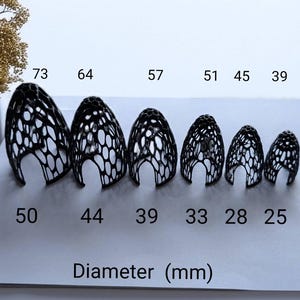 May include: Six black, open-weave, pod-shaped objects of varying sizes are displayed. The largest is 73 mm tall and 50 mm in diameter, while the smallest is 39 mm tall and 25 mm in diameter. The text "Height (mm)" and "Diameter (mm)" are also visible.