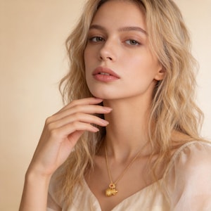 Handmade 18K gold plated filigree gourd pendant necklace featuring matte finish surface. Classic double-bulb Hulu shape with intricate cloud scroll openwork patterns. Stylized four-lobed flower bail with vibrant red gemstone center accent. Twisted rope chain, nickel-free copper alloy. 50cm length, 10g weight. Lucky charm symbolizing health and prosperity.