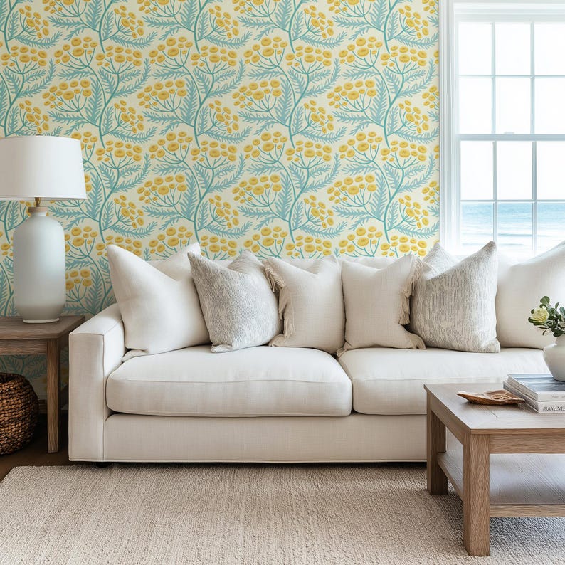 a living room with a white sofa, a wooden coffee table, and a lamp. The walls are decorated with a floral wallpaper pattern in shades of yellow and green.