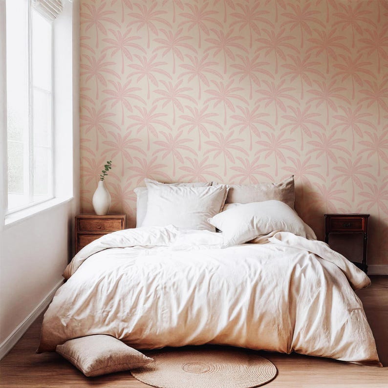 Puede incluir: Un dormitorio con papel tapiz de patr&oacute;n repetitivo de hojas de palmera en rosa claro. La cama est&aacute; vestida con una funda n&oacute;rdica y almohadas de color crema. Un jarr&oacute;n blanco descansa sobre una mesita de noche de madera y una alfombra redonda.