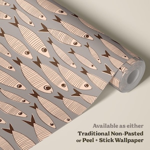 May include: A roll of wallpaper featuring a repeating pattern of light pink fish with dark brown outlines and striped details on a solid gray background. The text on the image reads: Available as either Traditional Non-Pasted or Peel + Stick Wallpaper.