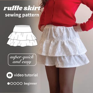 May include: A white, tiered ruffle skirt sewing pattern. The image includes the text "ruffle skirt sewing pattern", "super quick and easy", and "video tutorial". The skirt is made of white fabric with floral embroidery. The word "beginner" is also included.