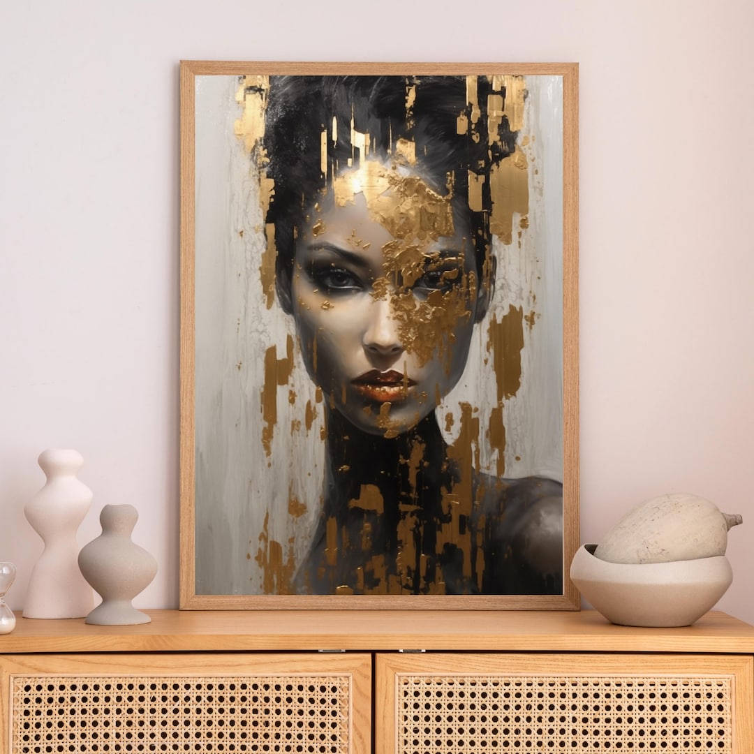 Gold Leaf Woman Portrait: a dark-haired woman with a direct gaze, gold leaf applied across her face and hair against a white and gray background, framed.