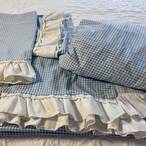 May include: A white ceramic mug with a black handle and the text "But First, Coffee" in a bold, black font. The mug is filled with a dark liquid, likely coffee, and sits on a light-colored surface.