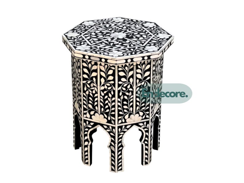 May include: Black and white octagonal side table with floral inlay design. The table features a detailed pattern on the top and sides, with arched cutouts at the base. A decorative accent piece for any room.