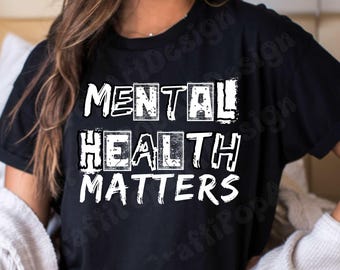May include: Black t-shirt with the white text "MENTAL HEALTH MATTERS". The text is in a bold, blocky font, with the word "MENTAL" in individual boxes. The shirt is a short-sleeved crew neck.