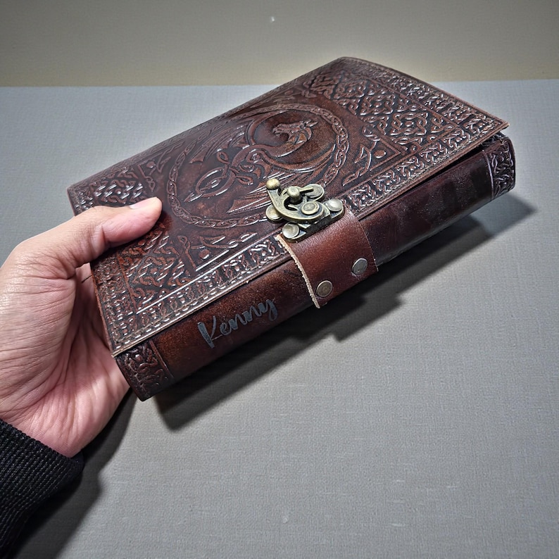 Personalized handmade brown leather journal with engraved Celtic dragon design and vintage metal clasp, refillable travel notebook gift