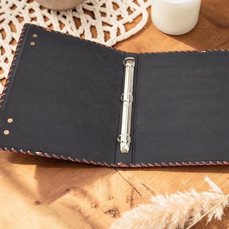 Open leather pentagram binder showing inner pages and ring mechanism, journal interior