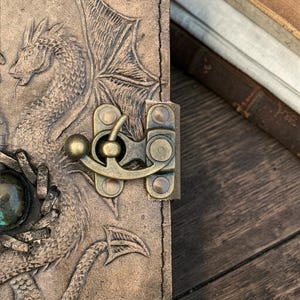 Close up of metal lock clasp on double dragon leather journal secure closure detail