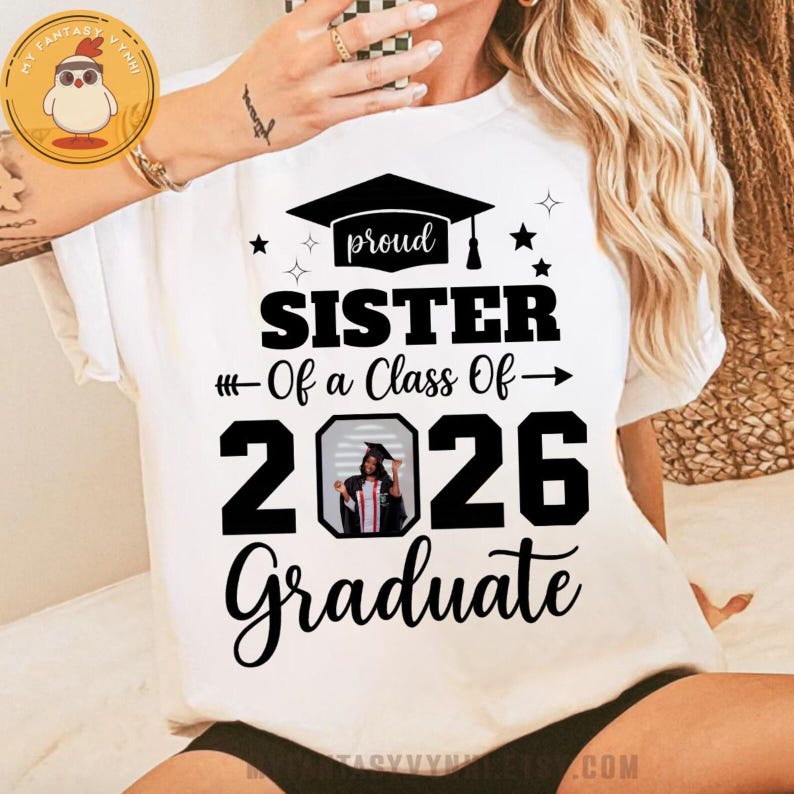 May include: White t-shirt with the text "proud SISTER Of a Class Of - 2026 Graduate". The design includes a graduation cap, stars, and an image of a graduate. A perfect gift for a proud sister.