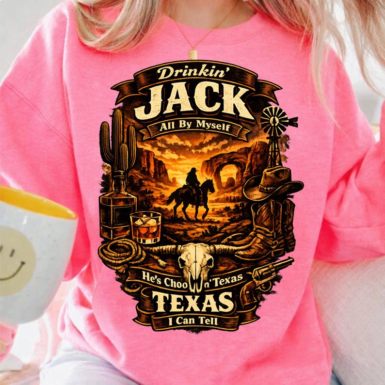 Puede incluir: Sudadera rosa brillante con un dise&ntilde;o de tem&aacute;tica occidental. El dise&ntilde;o incluye un vaquero a caballo, un molino de viento y el texto "Drinkin' Jack All By Myself". El dise&ntilde;o tambi&eacute;n presenta un cactus, whisky y el texto "Texas I Can Tell."