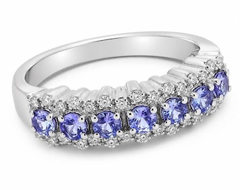 May include: A silver-toned ring featuring a central row of seven round-cut purple tanzanite gemstones, flanked by two rows of small, clear, round-cut white diamonds set along the band in a multi-stone cluster arrangement.
