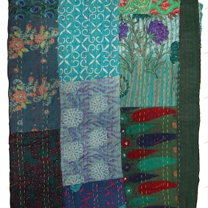 May include: A patchwork quilt with a variety of patterns and colors. The quilt features floral, paisley, and geometric designs in shades of teal, green, blue, and red. The edges are finished with a dark green border and stitched with white thread.
