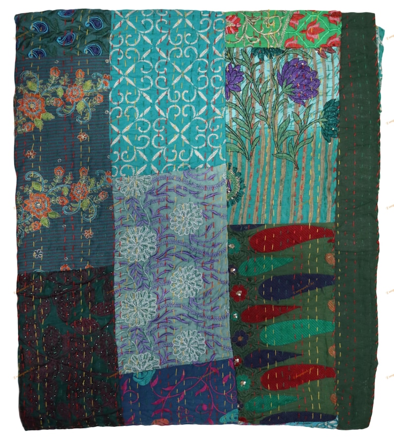 May include: A patchwork quilt with a variety of patterns and colors. The quilt features floral, paisley, and geometric designs in shades of teal, green, blue, and red. The edges are finished with a dark green border and stitched with white thread.