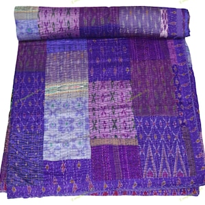 Peut inclure: Une courtepointe patchwork pliée dans les tons de violet, lavande et violet. La courtepointe présente une variété de carrés de tissu à motifs, notamment des motifs géométriques et floraux. Les bords sont soigneusement cousus et la courtepointe semble douce et accueillante.