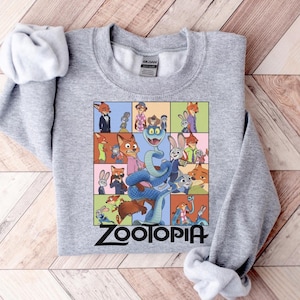 Pu&ograve; includere: Una felpa grigio melange con una grafica colorata dei personaggi del film d'animazione "Zootropolis". Il design &egrave; una griglia di immagini con il titolo del film in basso. Le maniche sono arrotolate.