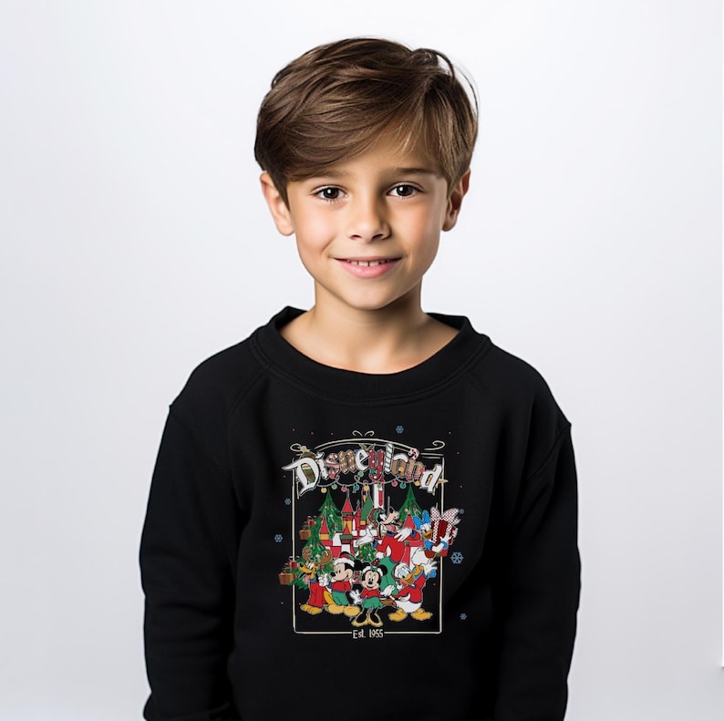 K&ouml;nnte beinhalten: Schwarzes Disneyland-Sweatshirt mit einem festlichen Motiv mit Mickey Mouse, Minnie Mouse, Donald Duck und anderen Disney-Figuren. Das Design umfasst Weihnachtsb&auml;ume und den Text "Disneyland - Est. 1955".