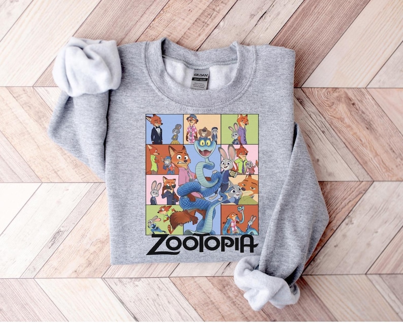 Pu&ograve; includere: Una felpa grigio melange con una grafica colorata dei personaggi del film d'animazione "Zootropolis". Il design &egrave; una griglia di immagini con il titolo del film in basso. Le maniche sono arrotolate.