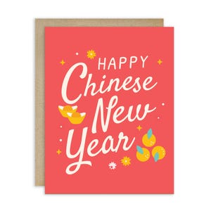 May include: A greeting card with a red background and the words "Happy Chinese New Year" in white script. The card features gold ingots, yellow flowers, and oranges. The card is set against a brown background.
