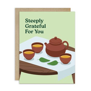 May include: Greeting card with a brown teapot, three tea cups, and two green leaves on a table. The card has the text "Steeply Grateful For You" in green letters on a light green background.