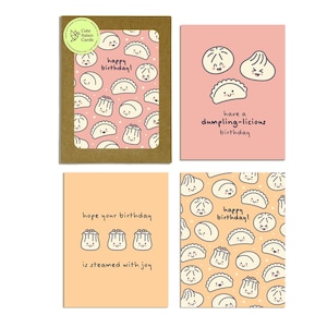 May include: A set of four greeting cards with dumpling illustrations. The cards feature phrases like "happy birthday!" and "have a dumpling-licious birthday." The cards have a cute, cartoonish style with a pink and orange color scheme.
