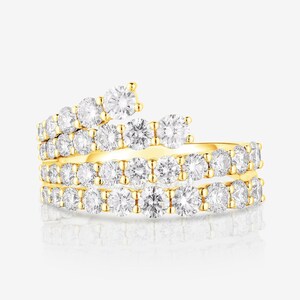 Puede incluir: Un anillo de estilo bypass elaborado en oro amarillo, con un diseño de varias filas que se envuelve alrededor del dedo. La banda está incrustada con numerosos diamantes blancos redondos de talla brillante en un engaste pavé continuo.