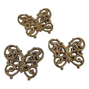May include: Three gold metal butterfly-shaped decorative accents with intricate filigree designs.