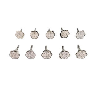 May include: A set of ten silver-toned metal knobs, each featuring a circular flower-shaped head with intricate embossed petal detailing and a central post for mounting. These hardware pieces have a metallic finish and a consistent floral design.