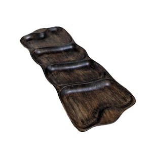 May include: A dark brown wooden serving tray featuring four distinct, connected compartments arranged in a linear, undulating shape. The surface displays a visible wood grain texture with a distressed, weathered finish throughout the entire piece.
