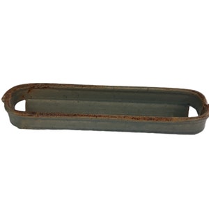 May include: A rectangular, light blue ceramic tray with a slightly raised rim and two curved handles. The rim has a distressed, rusty brown appearance, adding a vintage aesthetic. The tray is empty and sits against a white background.