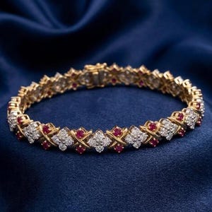 Könnte beinhalten: Ein goldenes Armband mit einem sich wiederholenden Muster aus weißen Diamanten und roten Edelsteinen. Das Armband ist vor einem dunkelblauen Hintergrund platziert, der das Funkeln der Edelsteine hervorhebt. Der Verschluss ist sichtbar.
