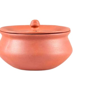 May include: A terracotta-colored, round cooking pot with a matching lid. The pot has a rounded body and a small knob on the lid. The pot is made of clay and is likely used for cooking or serving food. The pot is a warm, earthy tone.