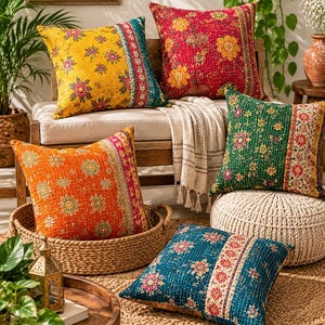 Könnte beinhalten: Fünf quadratische Zierkissen mit aufwendigen Steppnähten im Kantha-Stil und lebendigen Blumenmustern in Gelb, Rot, Orange, Grün und Blau. Jedes Kissen zeigt eine eigene Farbpalette mit einem kontrastierenden vertikalen Randdesign.
