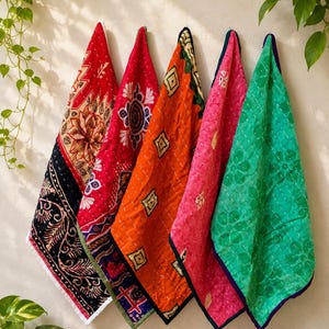 May include: Five rectangular quilted fabric pieces featuring kantha stitching and diverse patterns. The colors include black with floral motifs, red with geometric designs, orange with diamond shapes, pink with small patterns, and green with floral prints.