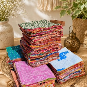 May include: A large stack of square fabric patches featuring various colourful patterns, including floral, geometric, and animal prints. The edges of the fabric pieces are frayed and layered, showcasing a mix of vibrant colours like pink, blue, and green.
