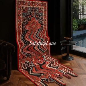 Könnte beinhalten: Ein roter, schwarzer und blauer gemusterter Teppich mit einem einzigartigen Schmelzdesign. Der Teppich lehnt an einer schwarzen Wand und trägt den Text "SafaRugLane". Der Teppich liegt auf einem Holzboden.