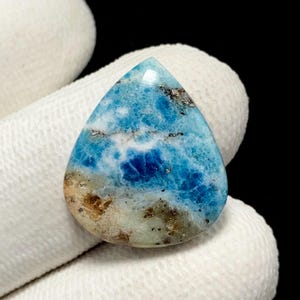 May include: A pear-shaped gemstone featuring a vibrant blue and white marbled pattern with patches of earthy brown and tan inclusions. The stone has a smooth, polished surface with a glossy finish, displaying natural mineral variations throughout.