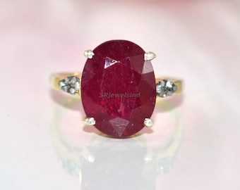 Eleganter ovaler Rubinring mit funkelnden seitlichen Diamanten in Gold-Finish, perfekt für besondere Anlässe, Geschenke oder als Statement-Modeschmuck.