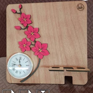 May include: Wooden desk organizer with a clock and floral design. The light brown organizer features a clock with Roman numerals, pink flowers, and a phone stand. The text "PDF SVG 3mm" is at the bottom.