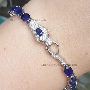 May include: A set of three ceramic nesting bowls in shades of blue, green, and white. The bowls feature a speckled glaze and a simple, modern design. The largest bowl measures approximately 6 inches in diameter.