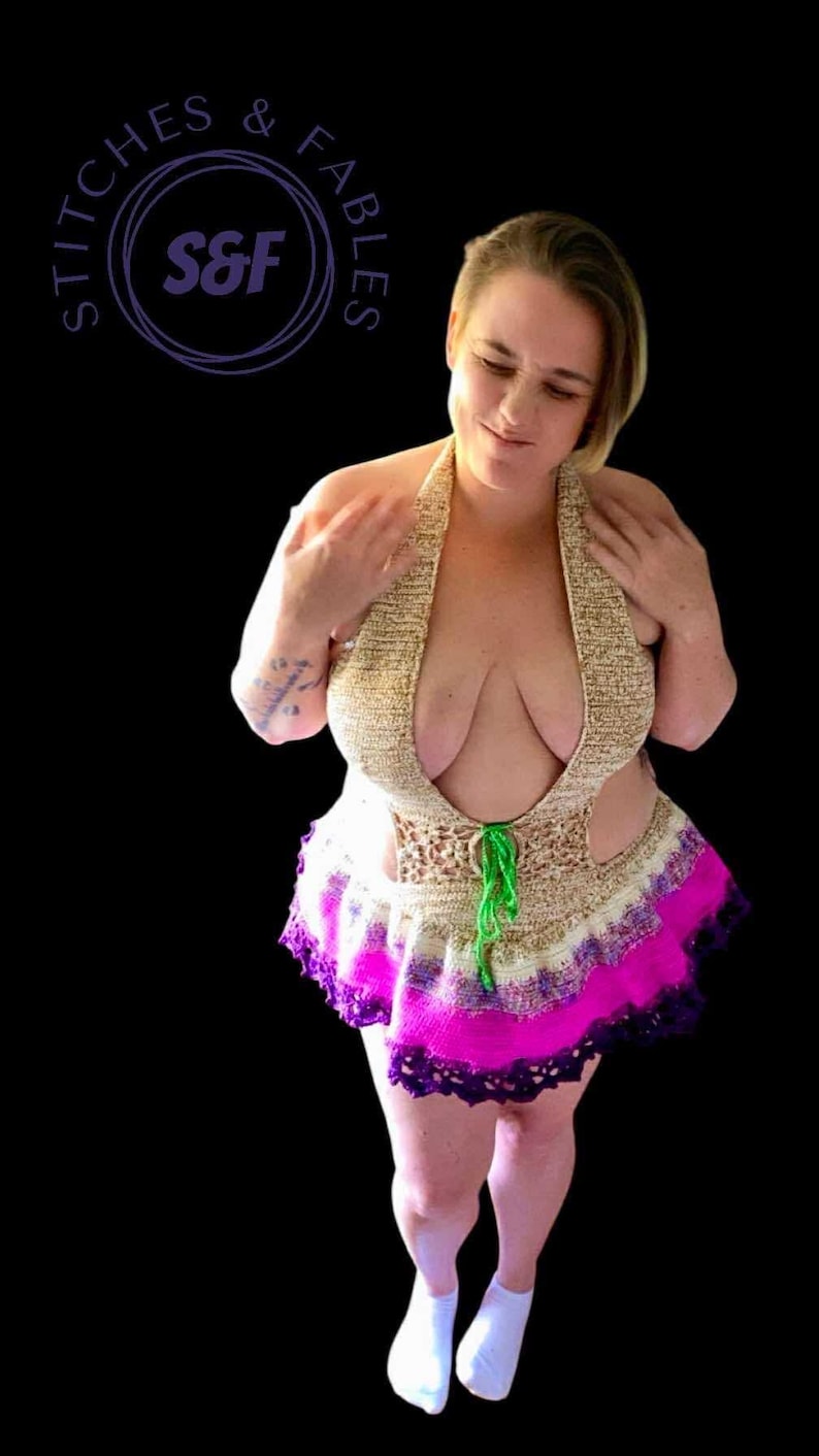 May include: A handmade halter top and skirt set. The top is beige with a deep neckline, and the skirt features a vibrant pink and purple trim. The set is tied with a green cord. The image includes the text "Stitches & Fables" in a circular logo.