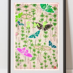 以下が含まれることがあります： ピンクとグリーンの蝶と花の模様が描かれた額入りのアートプリント。アートワークには緑色の「SMP」という文字が含まれています。蝶はピンク、グリーン、ブルーで、薄いピンク色の背景に配置されています。