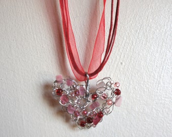 I Heart U. Valentine's Day crocheted wire heart pendant with pink cats eye and red beads on a red ribbon neck cord.