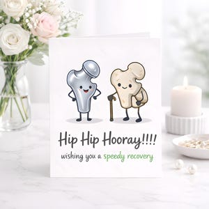 Op de afbeelding: Een beterschapskaart met de tekst "Hip Hip Hooray!!!! wishing you a speedy recovery." De kaart toont cartoon illustraties van een dijbeen en een heupbeen. Een vaas met bloemen en een brandende kaars staan op de achtergrond.