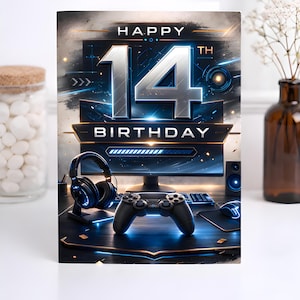 May include: A birthday card with a gaming theme. The card features a computer setup with a monitor, headphones, and a game controller. The words "HAPPY 14TH BIRTHDAY" are prominently displayed in silver and blue.