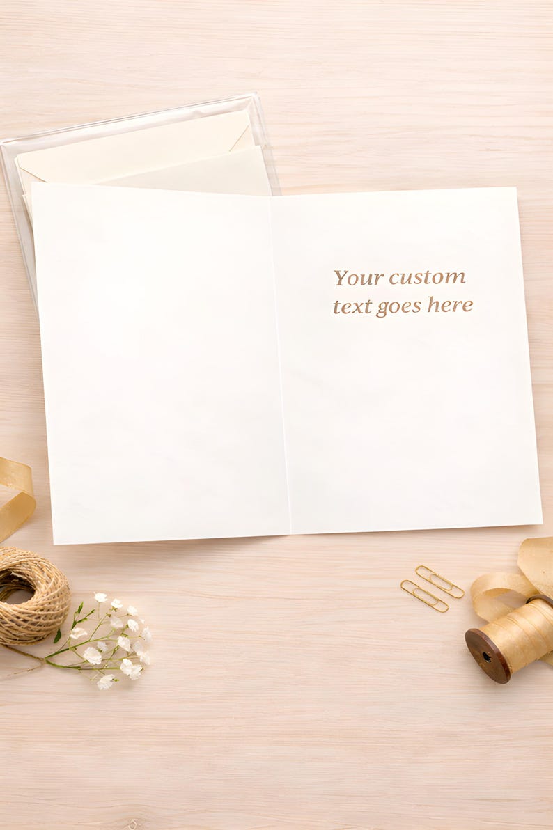 May include: A blank greeting card with the text "Your custom text goes here" printed in brown. The card is open on a light wood surface, with a clear plastic case, a spool of twine, paper clips, and decorative ribbon.