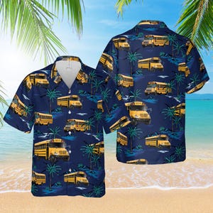 Puede incluir: Camisa azul marino de manga corta con un estampado repetido de autobuses escolares amarillos y palmeras. La camisa tiene un cuello clásico y está diseñada para un ajuste relajado. El fondo es una escena tropical.