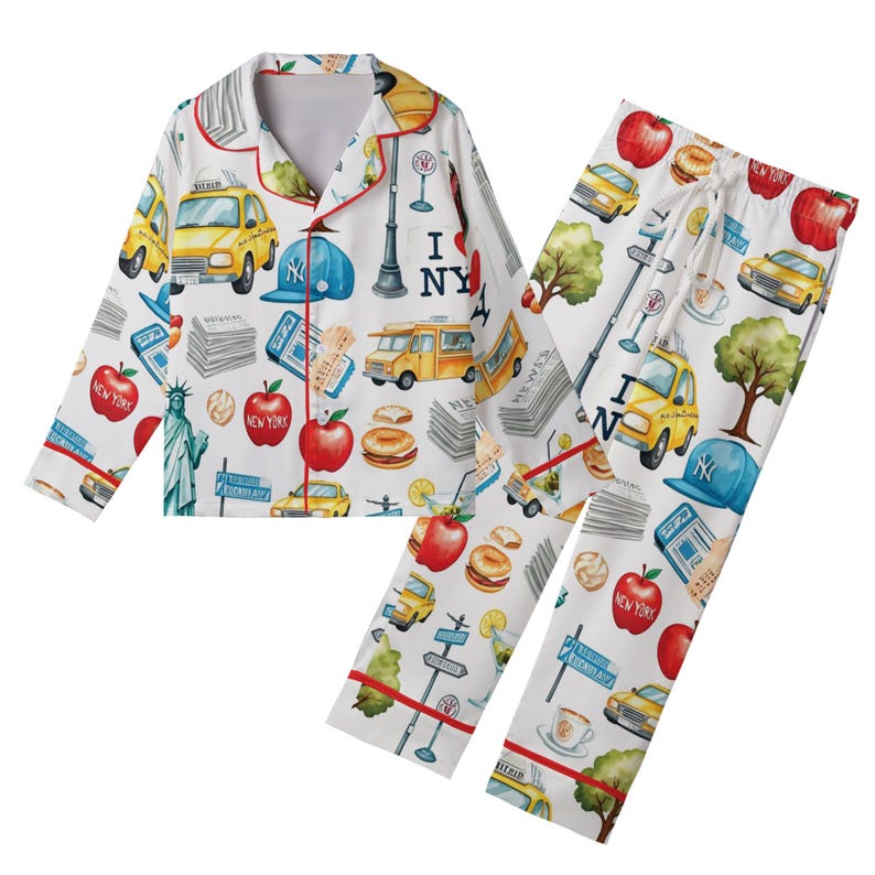 Puede incluir: Conjunto de pijama blanco con tem&aacute;tica de la ciudad de Nueva York. El conjunto incluye una camisa de manga larga con cuello y pantalones a juego. El estampado presenta taxis amarillos, manzanas rojas, la Estatua de la Libertad y el texto "I NY".